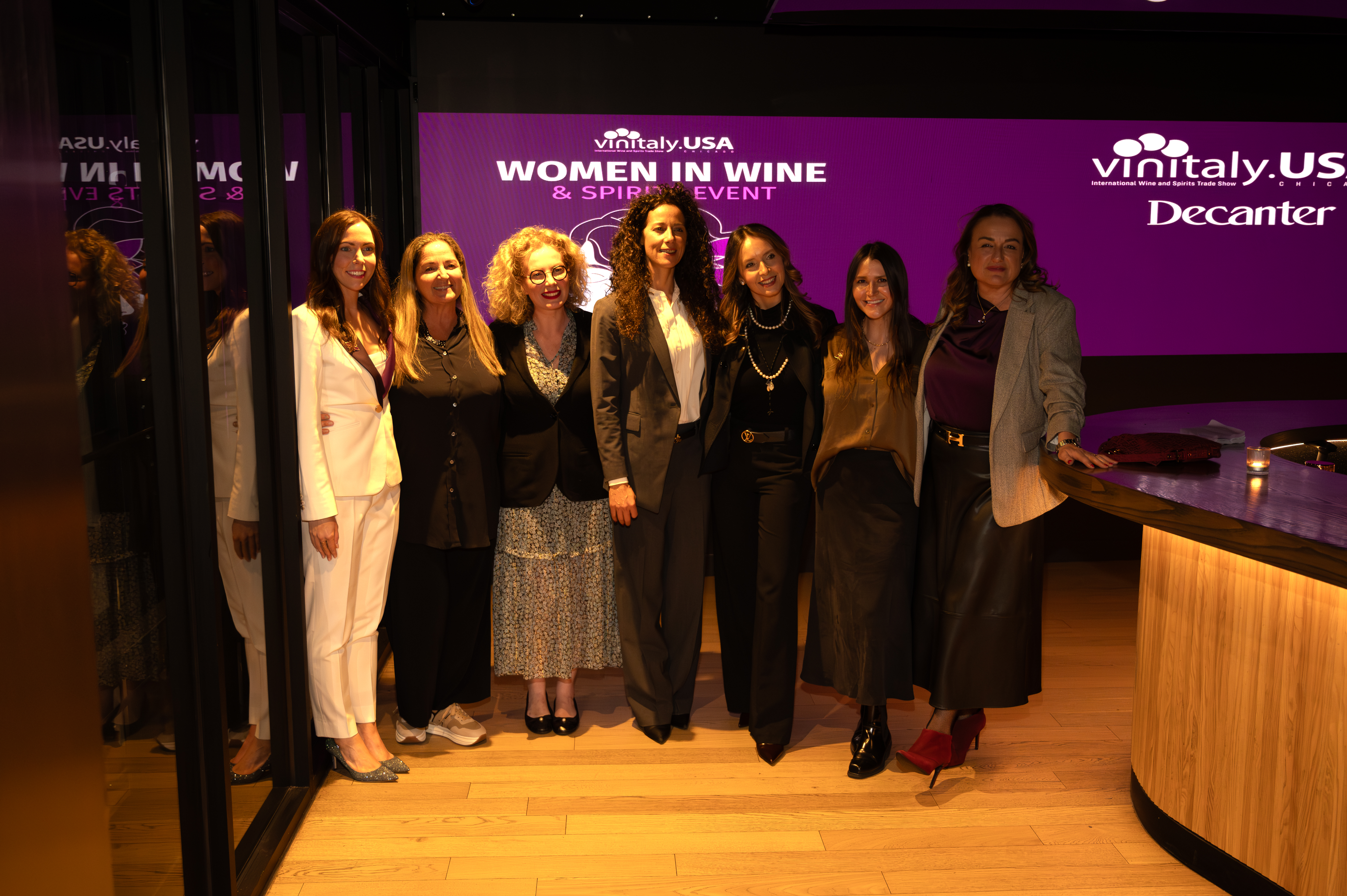 Women raising glasses during a Women in Wine & Spirits event.